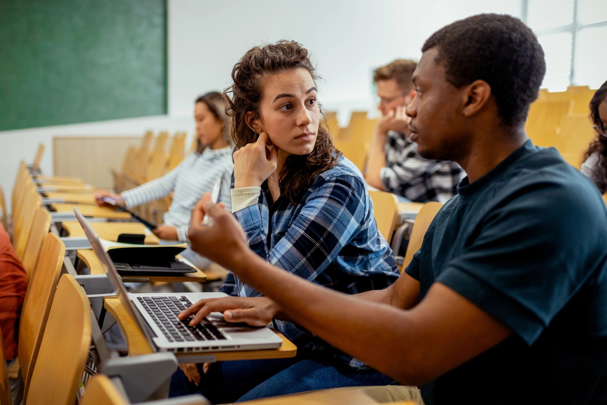 Students working together on a laptop at a table