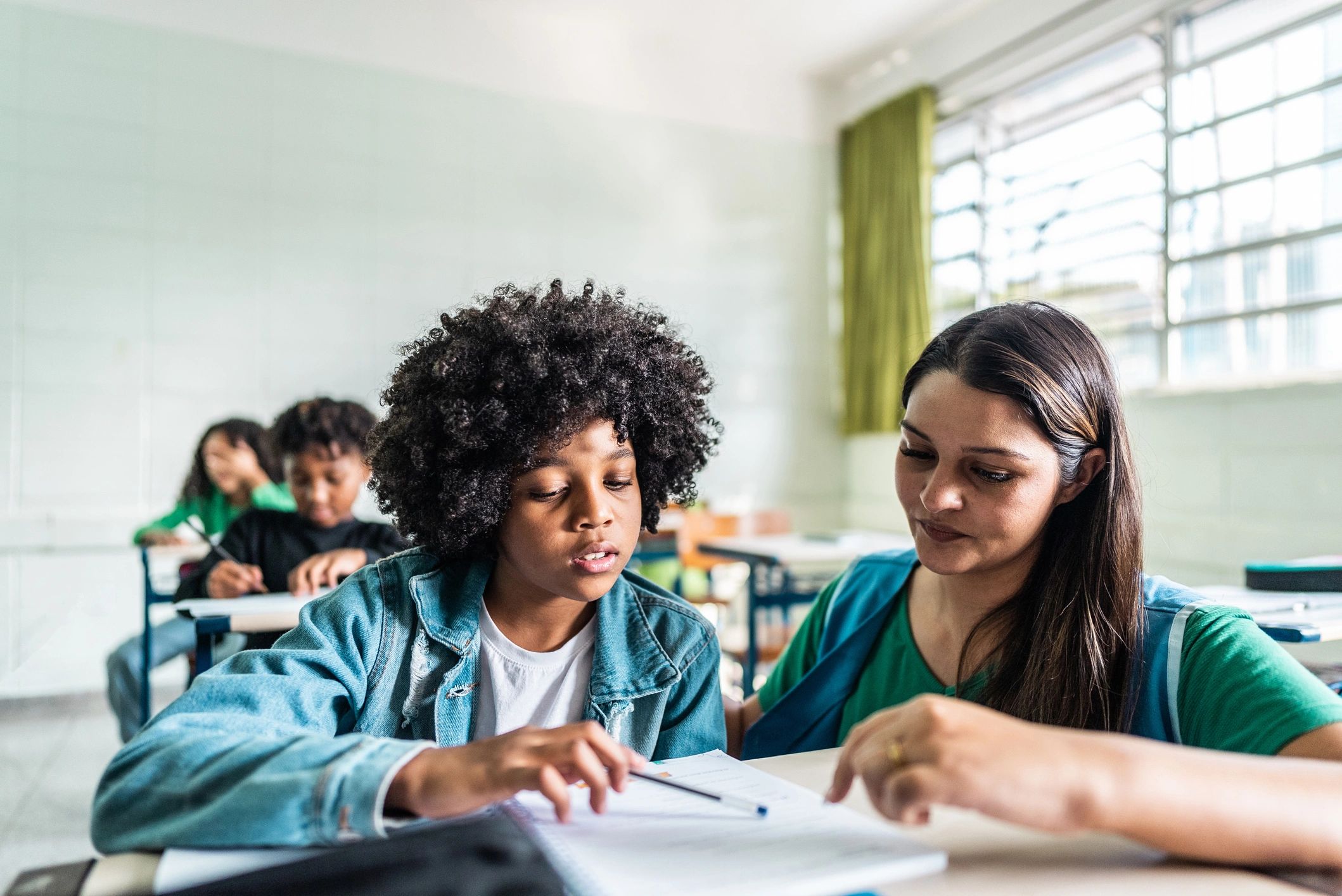 Teacher helping a student with a grammar workbook