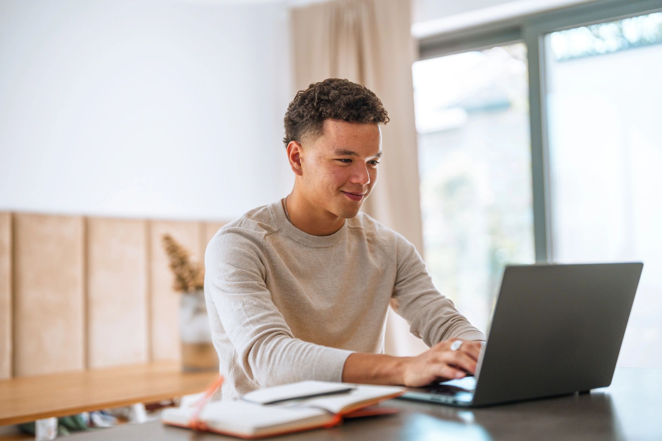 Student studying online with a laptop and notes