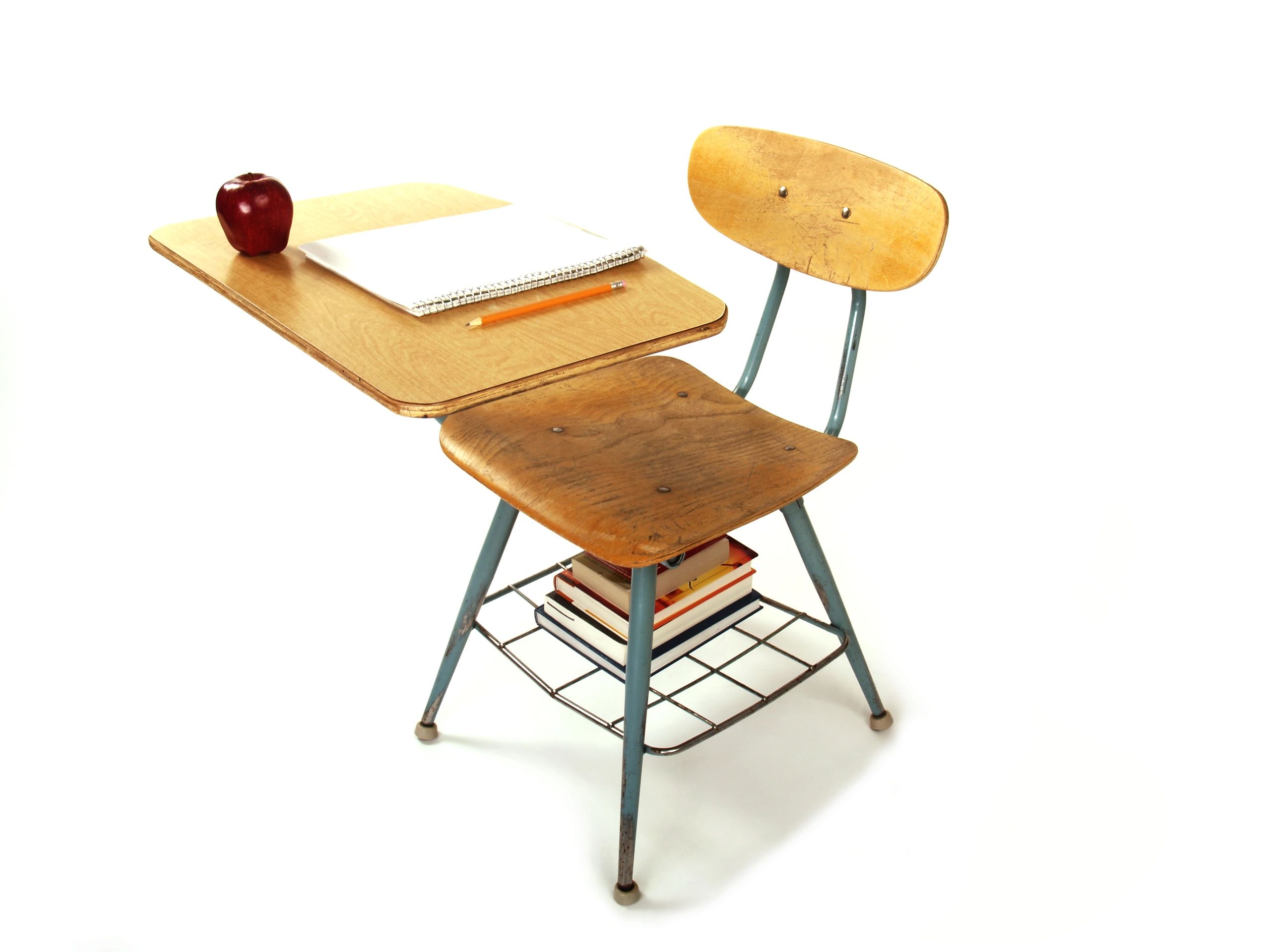 Classroom desk with books, paper, and pencil